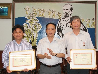 (L-R) Editor-in-Chief Tran The Tuyen, Lt. Gen. Vo Trong Viet, SGGP journalist Nguyen Duc Quang pose for picture after the signing of the MoU. (Photo: SGGP)